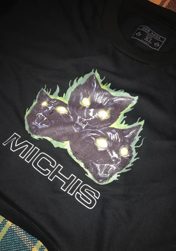 Remera negra crop top con estampa de 3 gatos furiosos y en llamas. Debajo una palabra: michis
