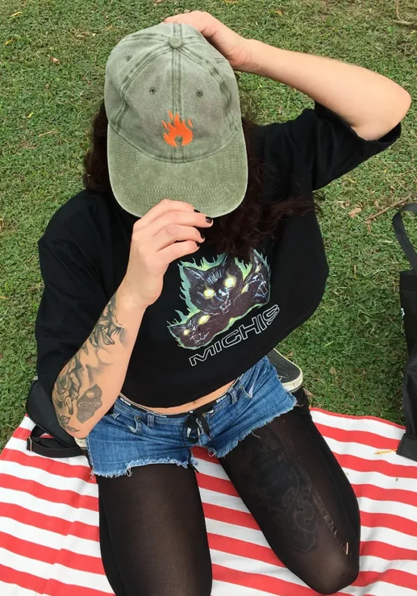Remera negra crop top con estampa de 3 gatos furiosos y en llamas. Debajo una palabra: michis
