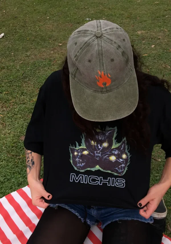 Remera negra crop top con estampa de 3 gatos furiosos y en llamas. Debajo una palabra: michis