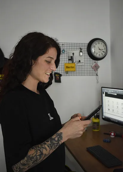 Diseñadora del estudio Que Arda revisando contenidos desde el celular en el estudio de Que arda